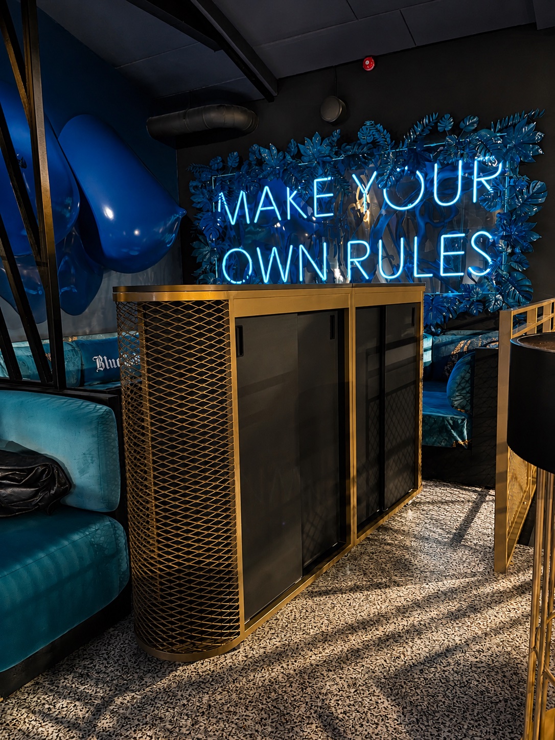 Blue Label interior with blue neon wall and gold-tone metal bar