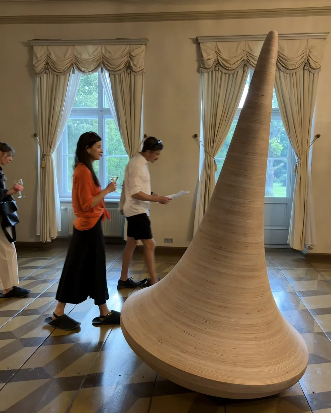 Large curved and tapered wood object in an exhibition room